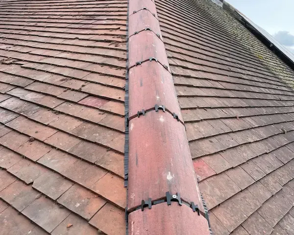 Roofer repairing slipped tiles on a domestic roof